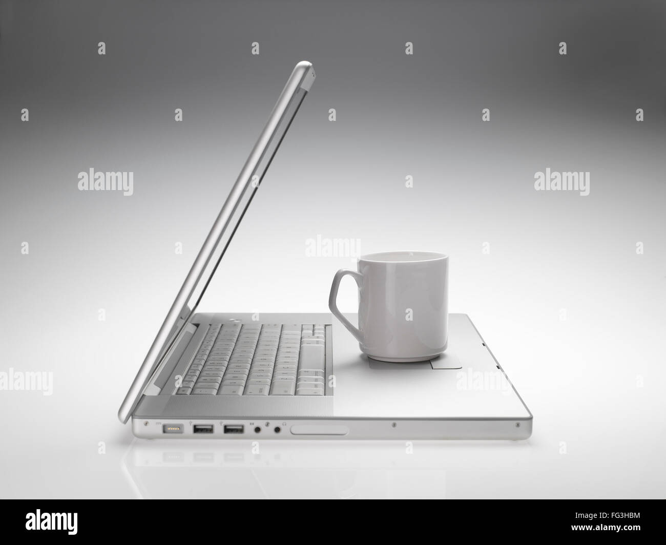 Becher auf Macintosh Laptop auf weißen grauen Hintergrund Stockfoto