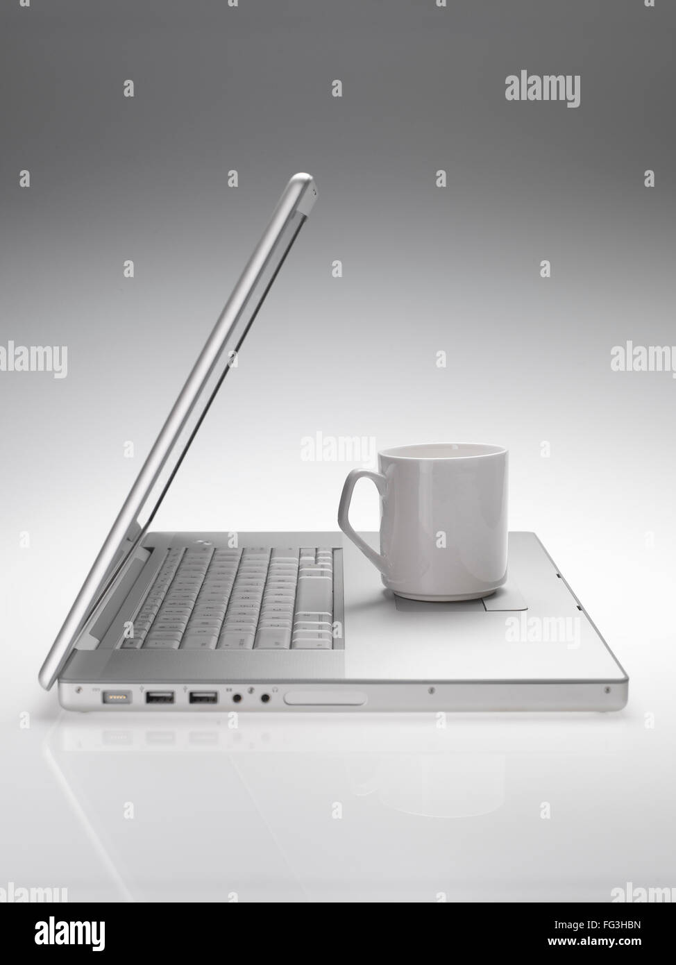 Becher auf Macintosh Laptop auf weißen grauen Hintergrund Stockfoto