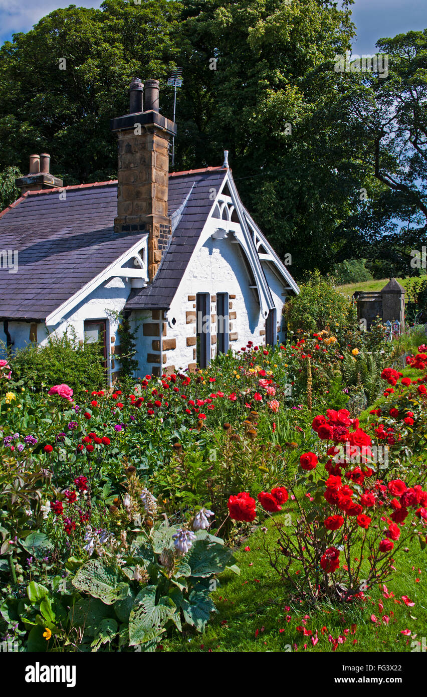 Idyllische malerischen schrulligen Cottage mit ziemlich Garten und rote Rosen blühen am Straßenrand kurz vor, in der Nähe von Great Ayton, North Yorkshire Stockfoto