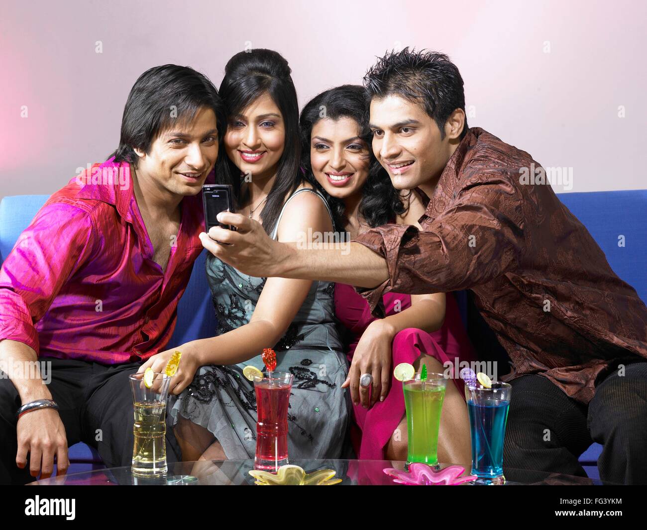 Südasiatische indischen Mann unter Gruppenfoto in mobile feiert Party Herr Stockfoto