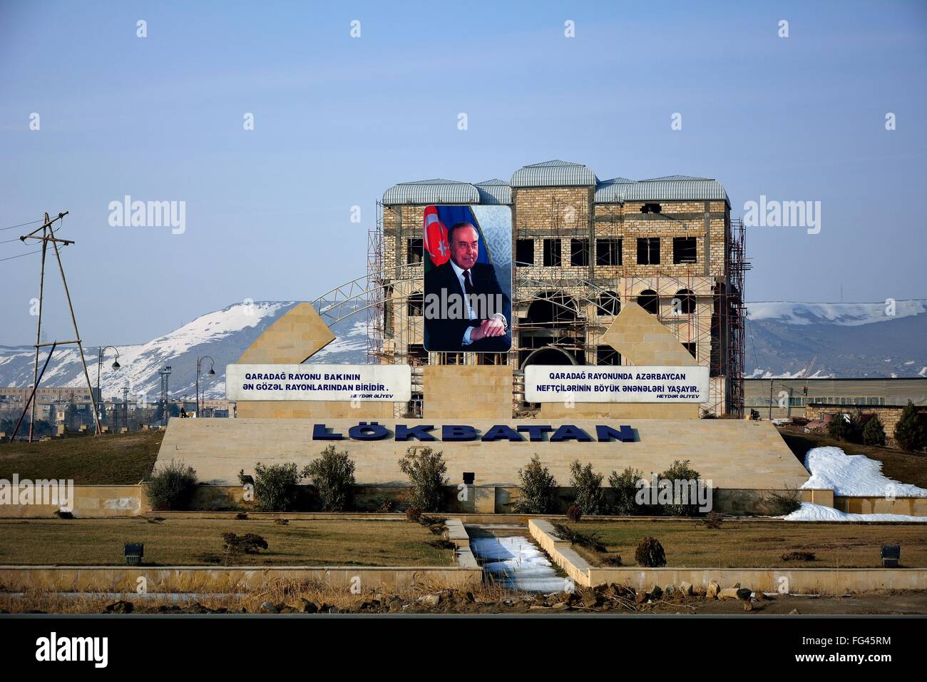 Unfertigen Gebäude in Lökbatan, Aserbaidschan, mit großen Bild von Heydar Aliyev. Stockfoto