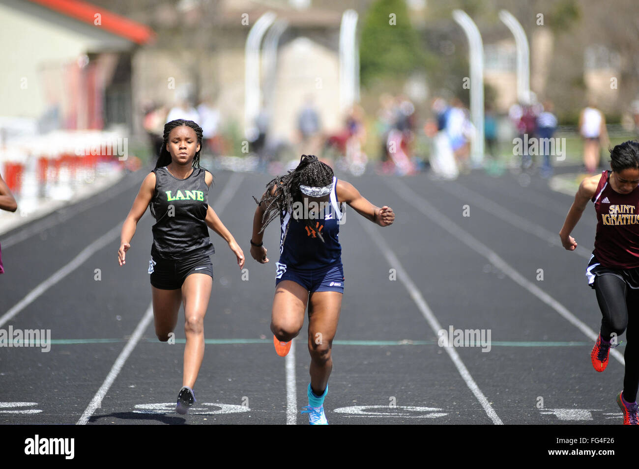 High School Athleten Belastung an der Ziellinie in einem eng umkämpften 100-Meter dash Hitze an einem High School Schiene Treffen. USA. Stockfoto