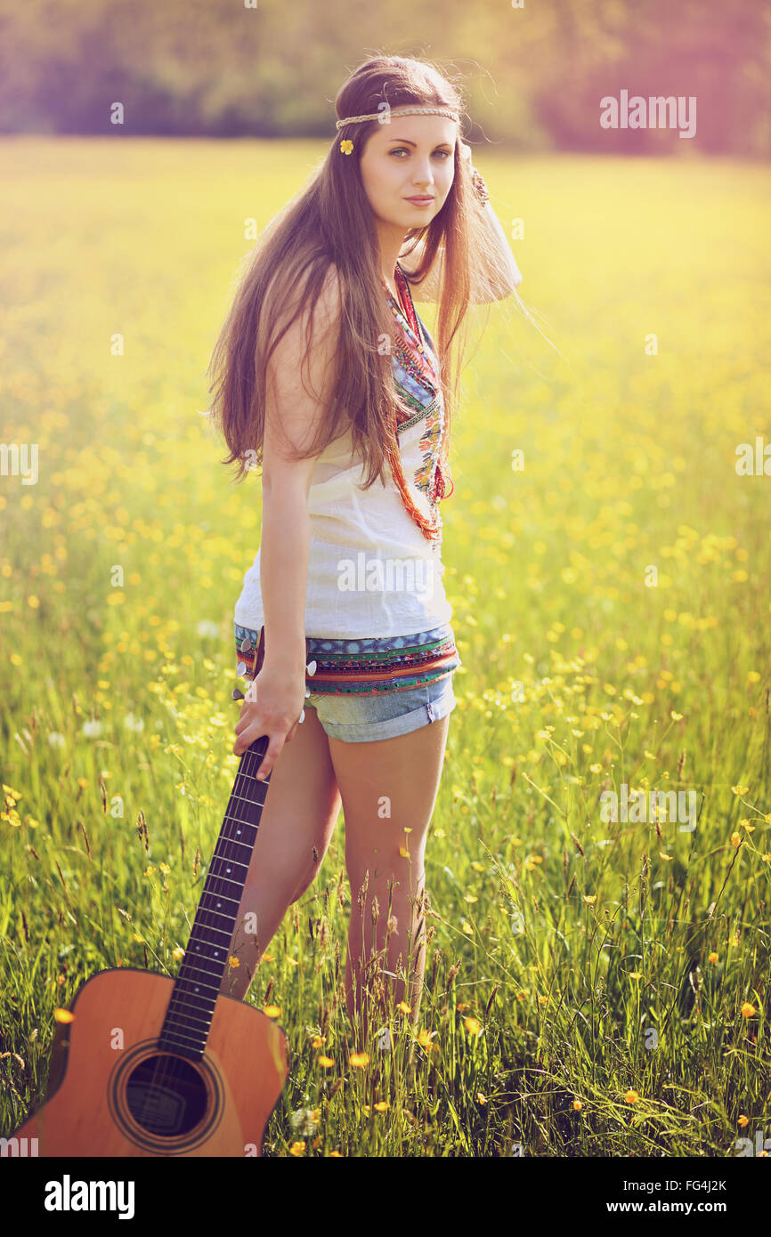Wunderschöne Hippie-Frau mit Gitarre. Sommer-Farben-Porträt Stockfoto