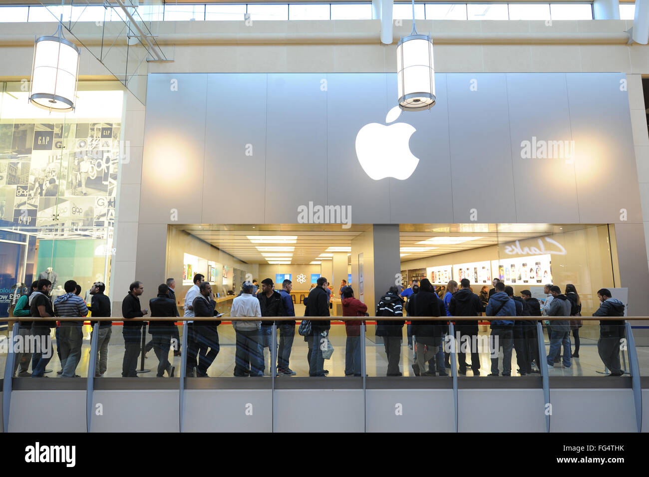 Shopper Schlange vor dem Apple Store in Cardiff, Südwales, für das neueste iPhone. Stockfoto