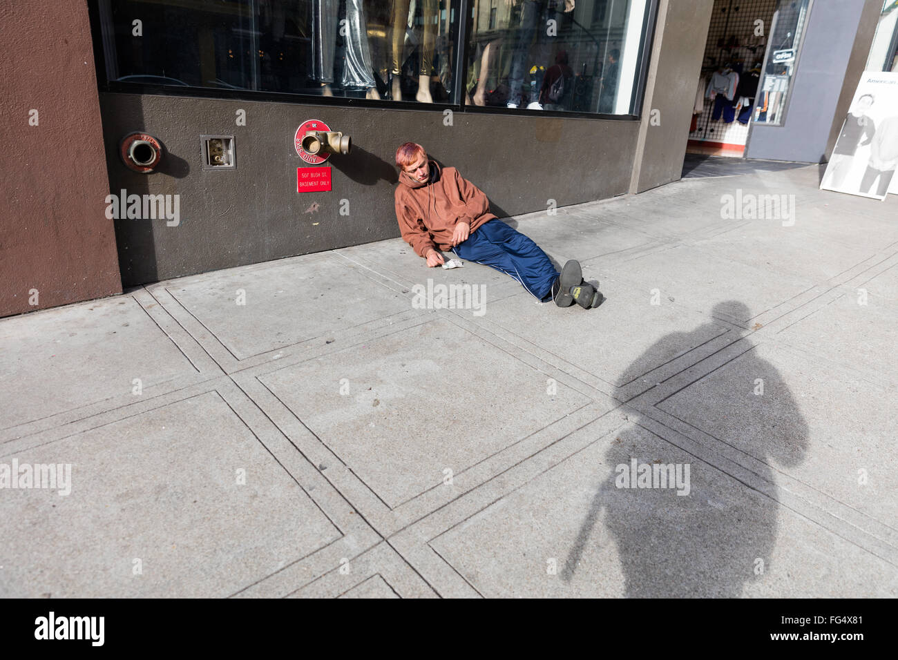 Junge Obdachlose Männer ruhen, Verlegung, auf dem Bürgersteig Stockfoto