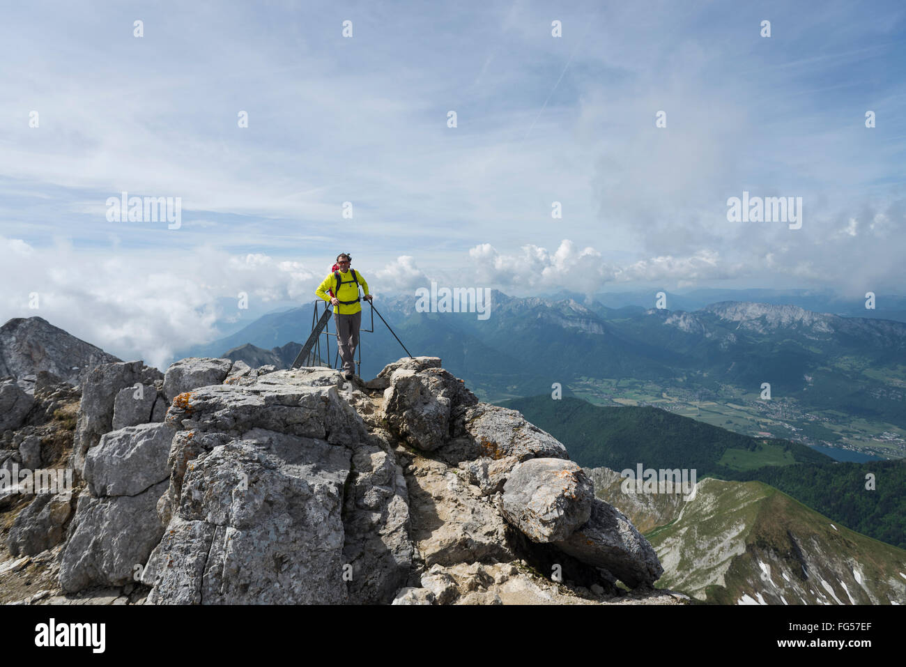 Männliche Wanderer auf die Leiter, die zum Gipfel des Berges Monte gelohnt überragt den See Annecy, Savoyen, Frankreich Stockfoto