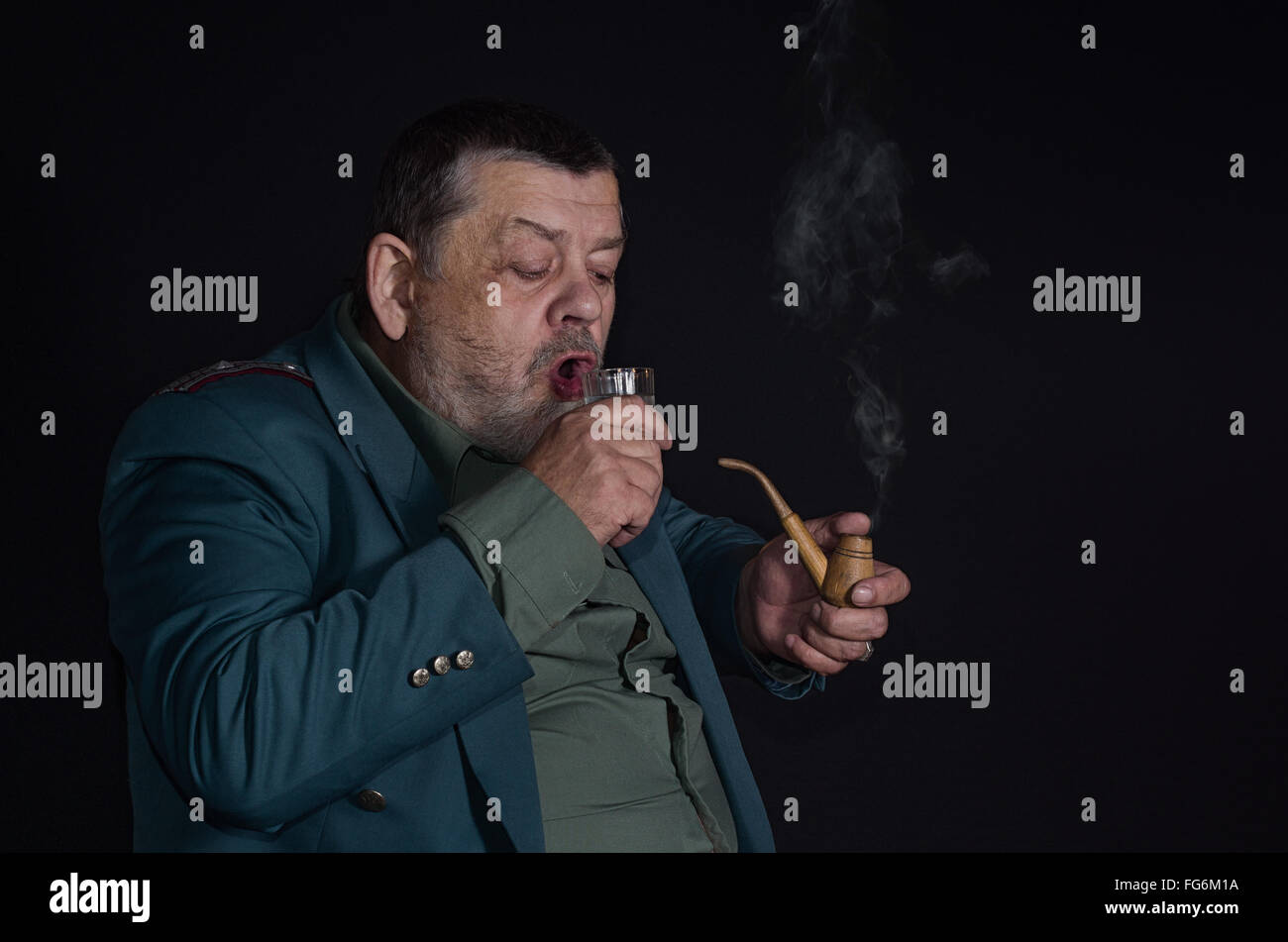 Porträt einer alten pensionierte militärische Mann, Glas Wodka beim Tabak-Pfeife trinkfertig ist Stockfoto