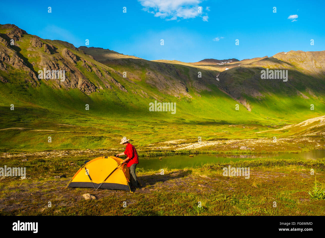 Ein Mann auf seinem Campingplatz am hängenden Tal in South Fork in der Nähe von Eagle River an einem Sommertag in South Central Alaska. Stockfoto