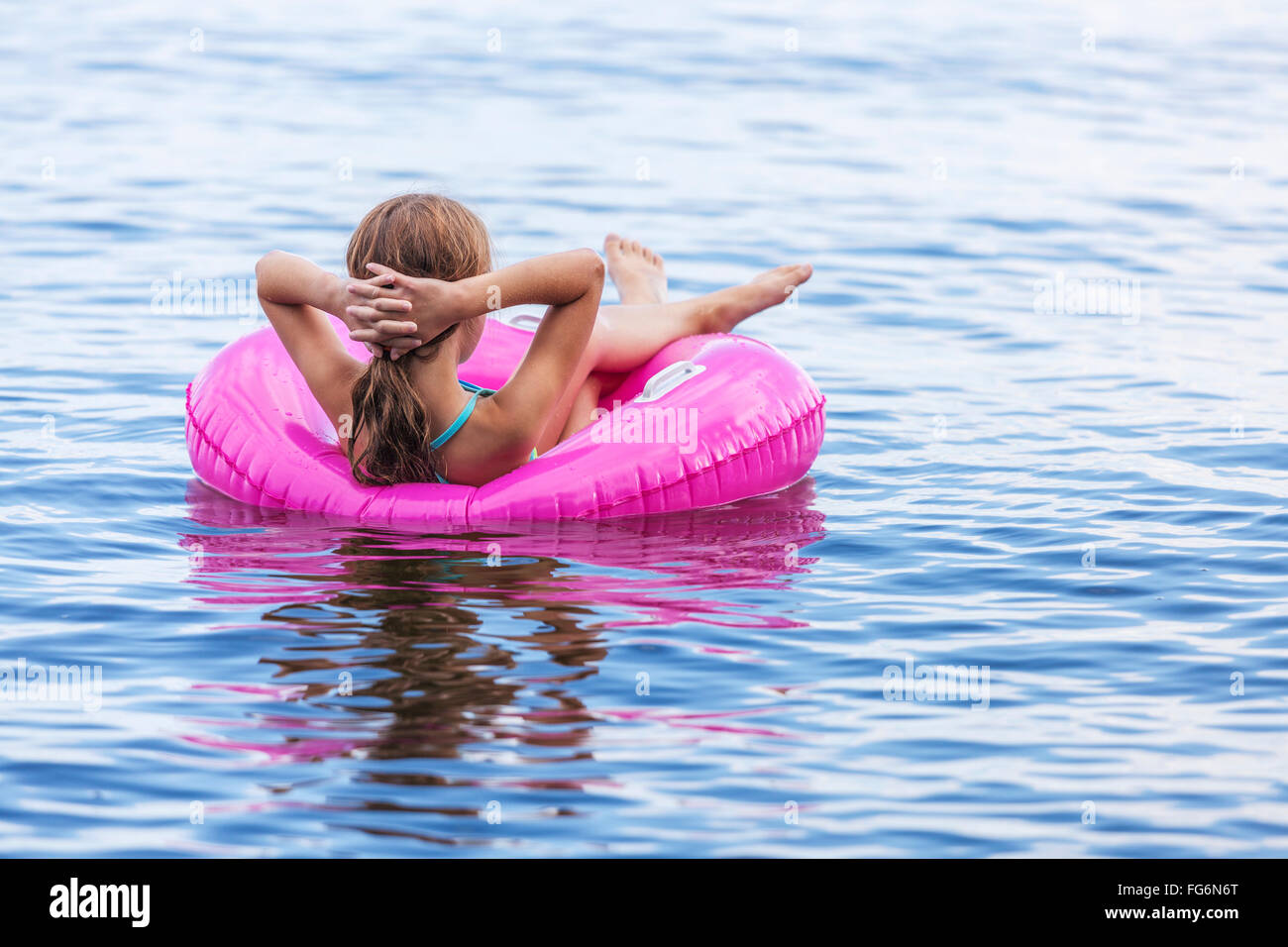 Mädchen in rosa aufblasbaren Ring auf Balsam Lake ruhen; Ontario, Kanada Stockfoto