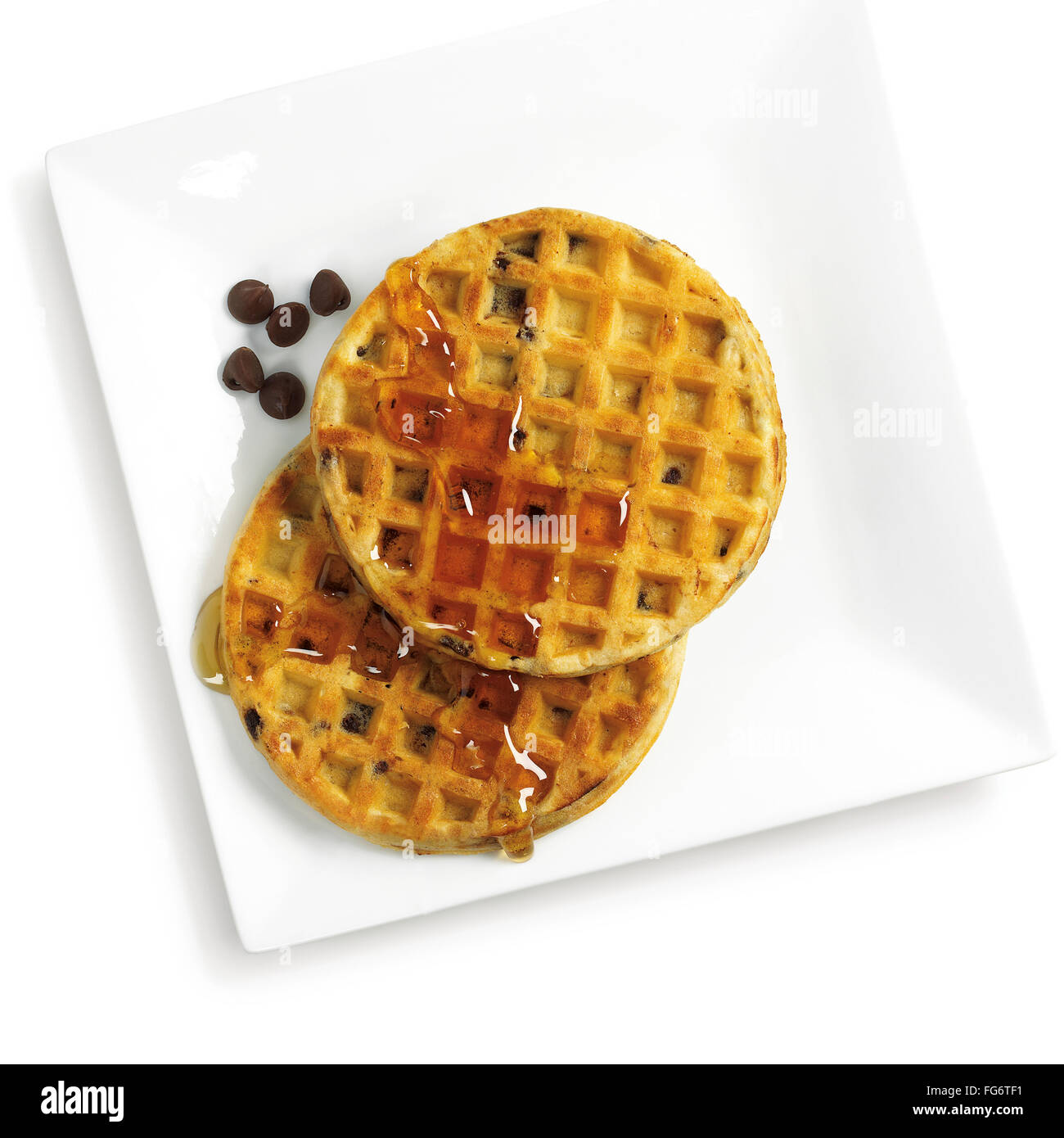 Waffeln, Sirup und Schokolade-Chips auf einem weißen Teller vor einem weißen Hintergrund; Toronto, Ontario, Kanada Stockfoto