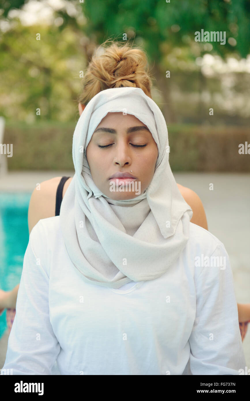 Frau beim Yoga am Pool in Dubai Stockfoto