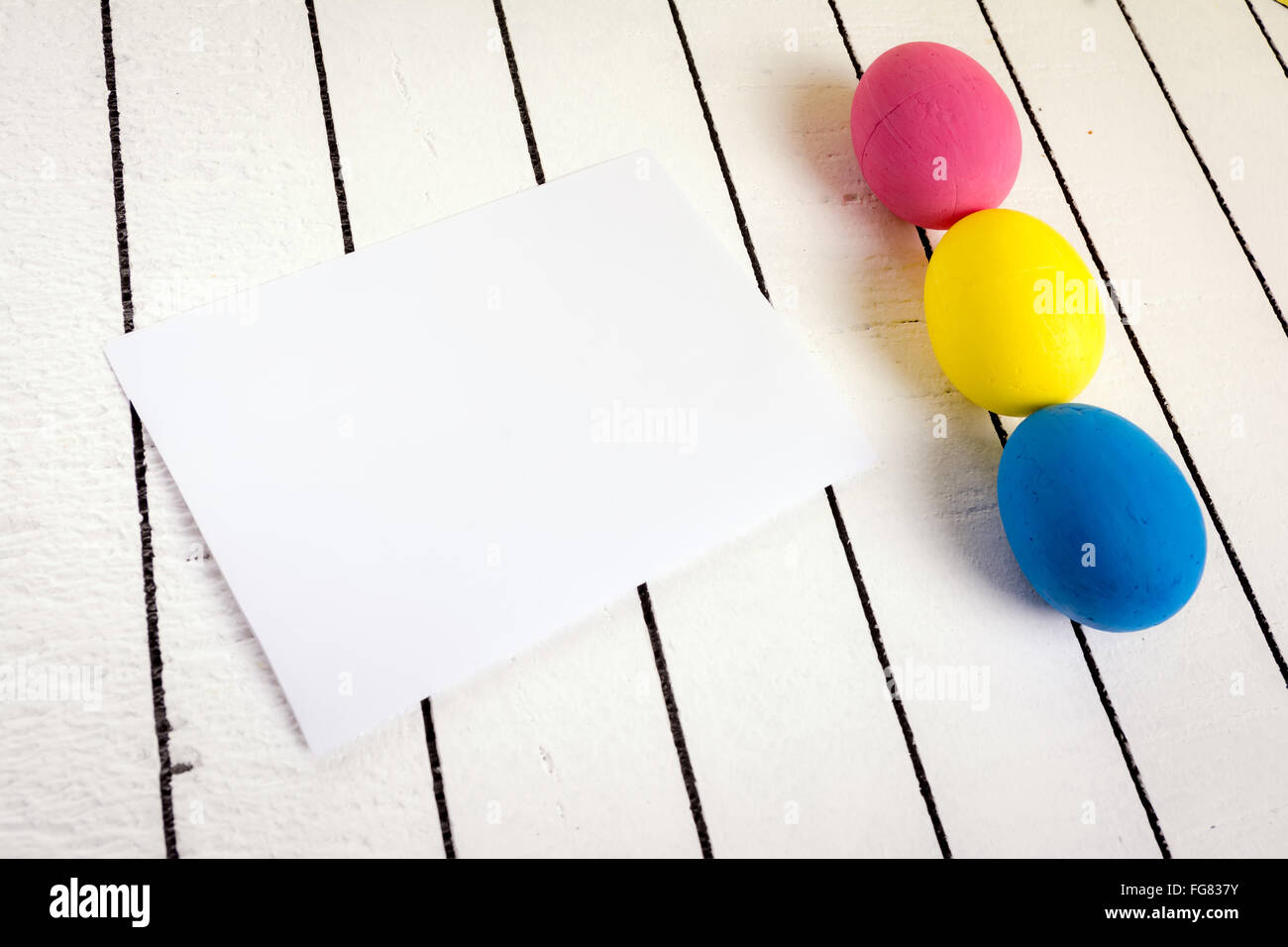 Bunte Ostereier und leeren weißen Blatt Holz Hintergrund. Umweltfreundliches Material ohne Gewalt gegen Tiere Stockfoto