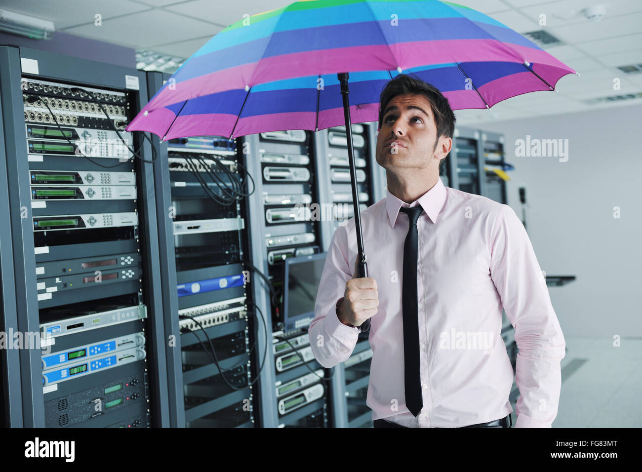 Geschäftsmann halten Regenschirm im Serverraum Stockfoto