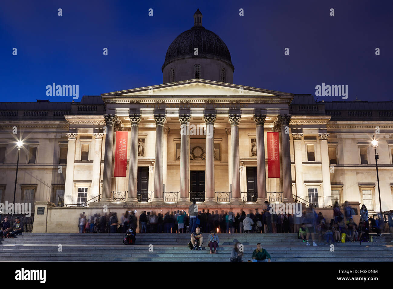 Die National Gallery am Trafalgar Square in London am Abend mit Publikum Stockfoto