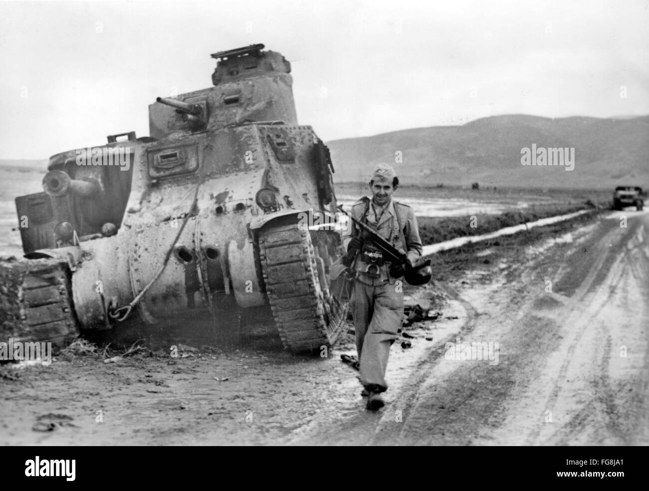 Das Nazi-Propagandafild zeigt ein Mitglied der deutschen Wehrmacht mit einem Maschinengewehr vor einem zerstörten US-Panzer in Tunesien. Das Foto wurde im Dezember 1942 aufgenommen. Fotoarchiv für Zeitgeschichtee - KEINE ÜBERWEISUNG - Stockfoto