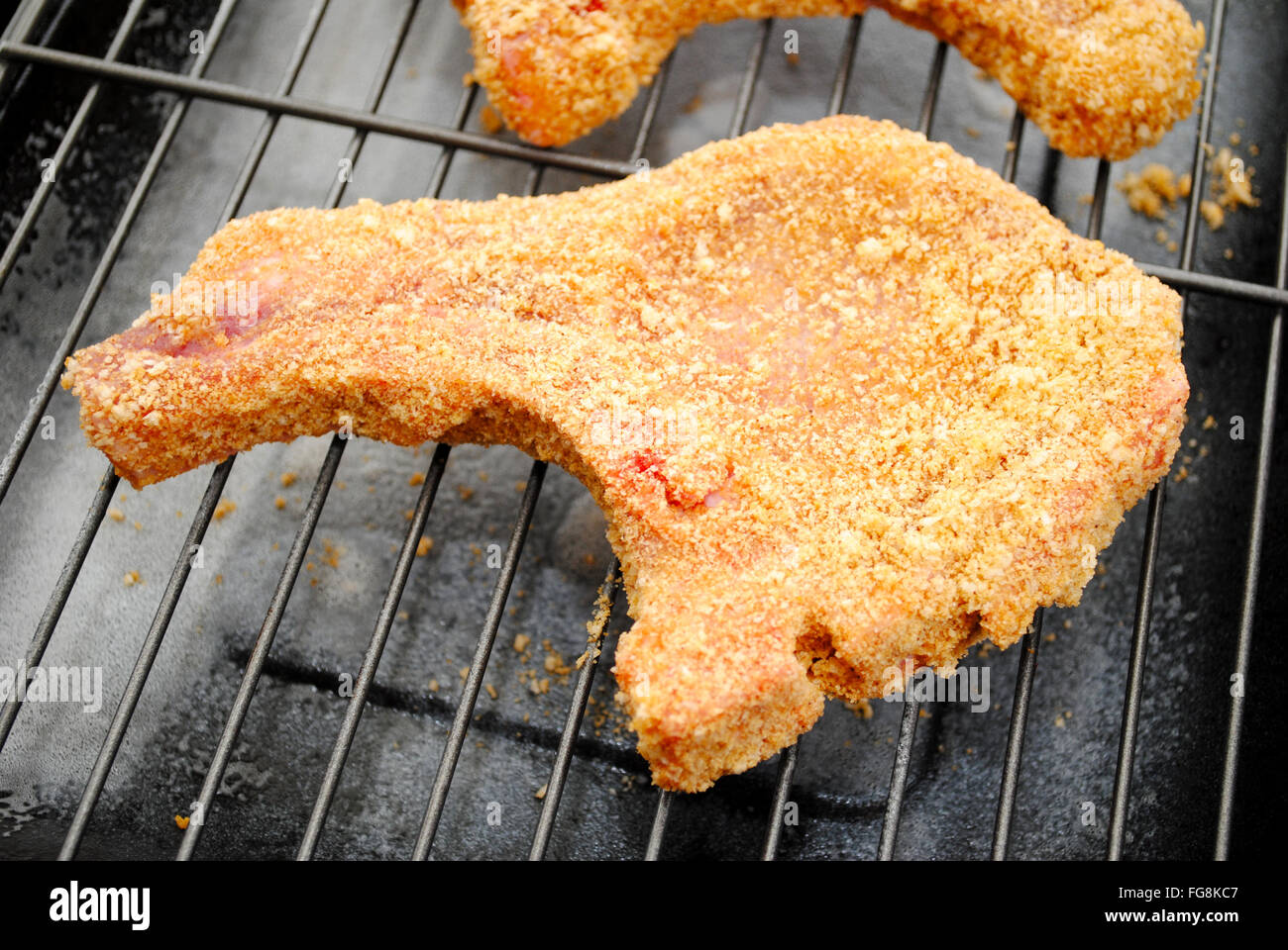 Paniertes Schweinekotelett fertig gebacken werden Stockfoto