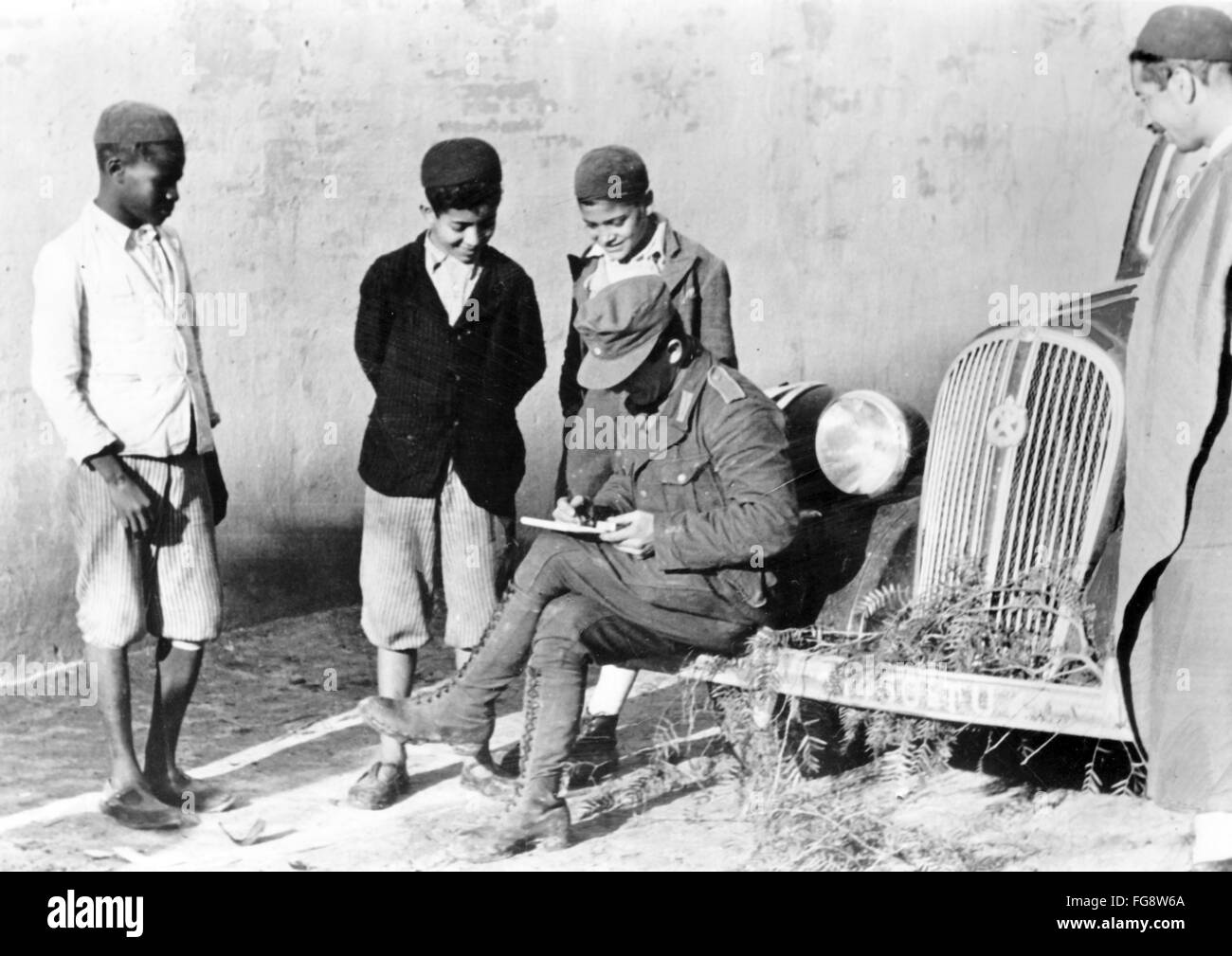 Das Nazi-Propagandafild zeigt Soldaten der deutschen Wehrmacht und einheimische tunesische Kinder beim Zeichnen. Das Foto wurde im März 1943 aufgenommen. Fotoarchiv für Zeitgeschichte - KEIN KABELDIENST - Stockfoto