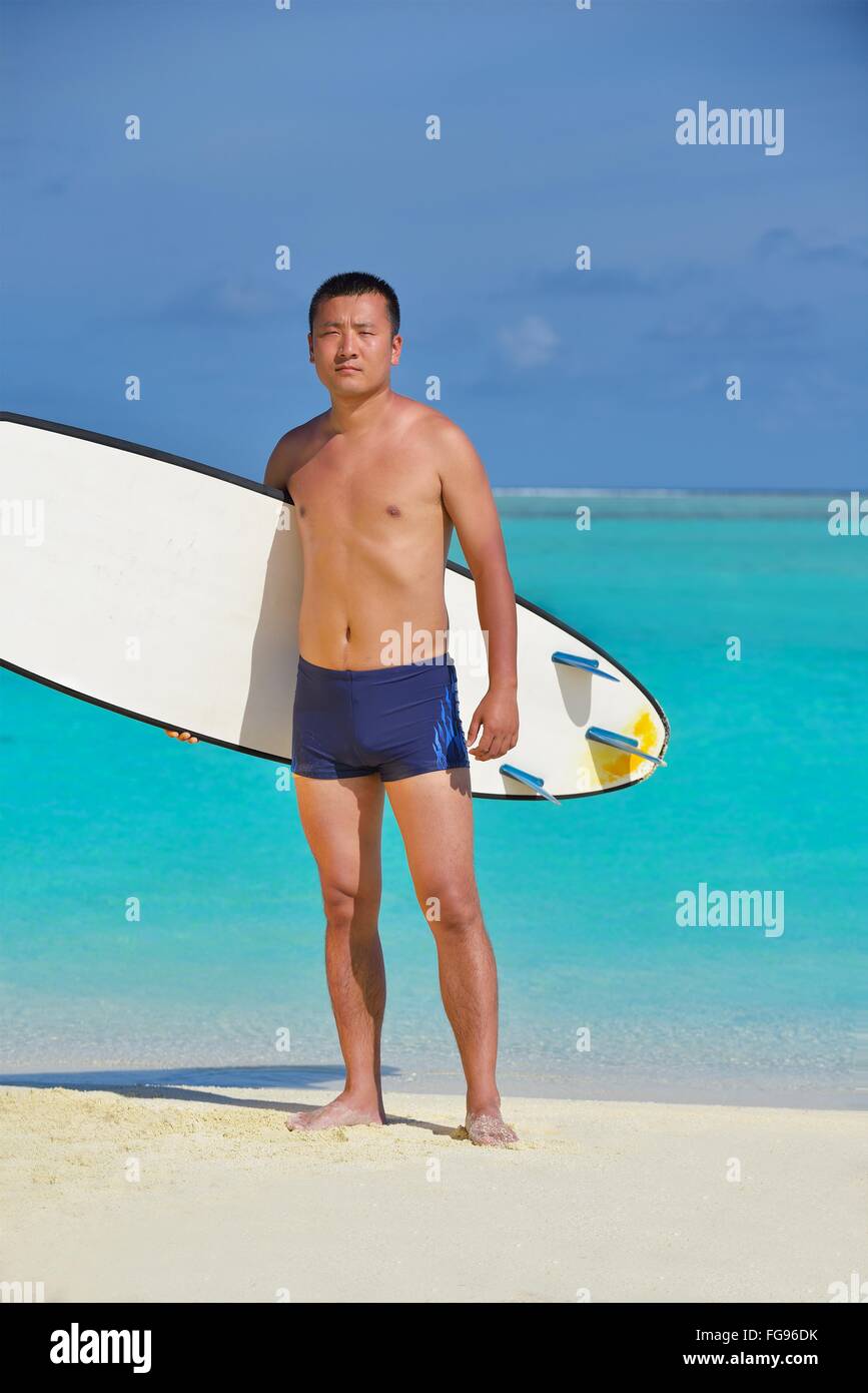 Mann mit Surfbrett am Strand Stockfoto