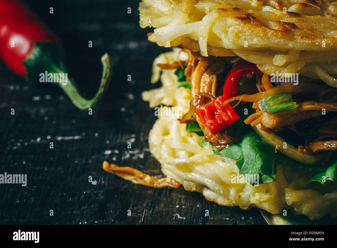 Abgeschnitten Bild der Frische Ramen-Burger mit roten Chili-Pfeffer Stockfoto