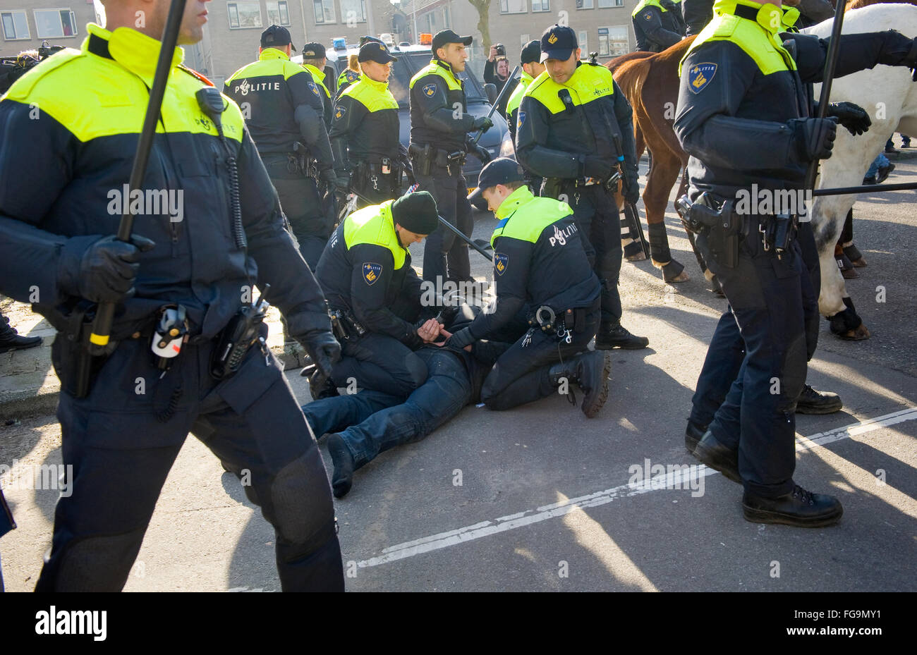 Ein Demonstrant gegen eine riesige Migranten Flüchtlingslager für Flüchtlinge ist von der Polizei verhaftet Stockfoto