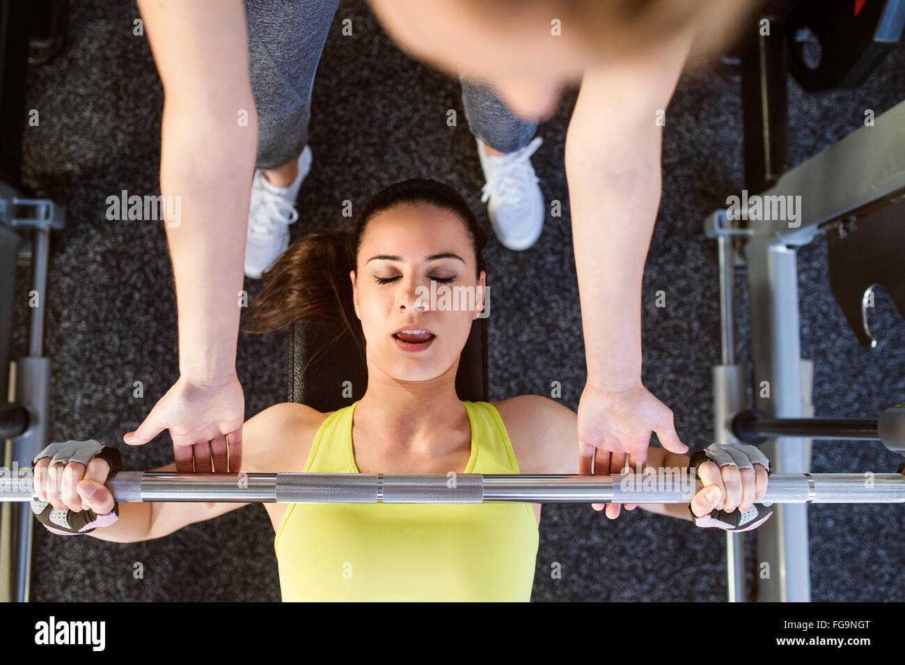 Frau mit Personaltrainer Bank drücken mit Gewichten, Fitness-Studio Stockfoto