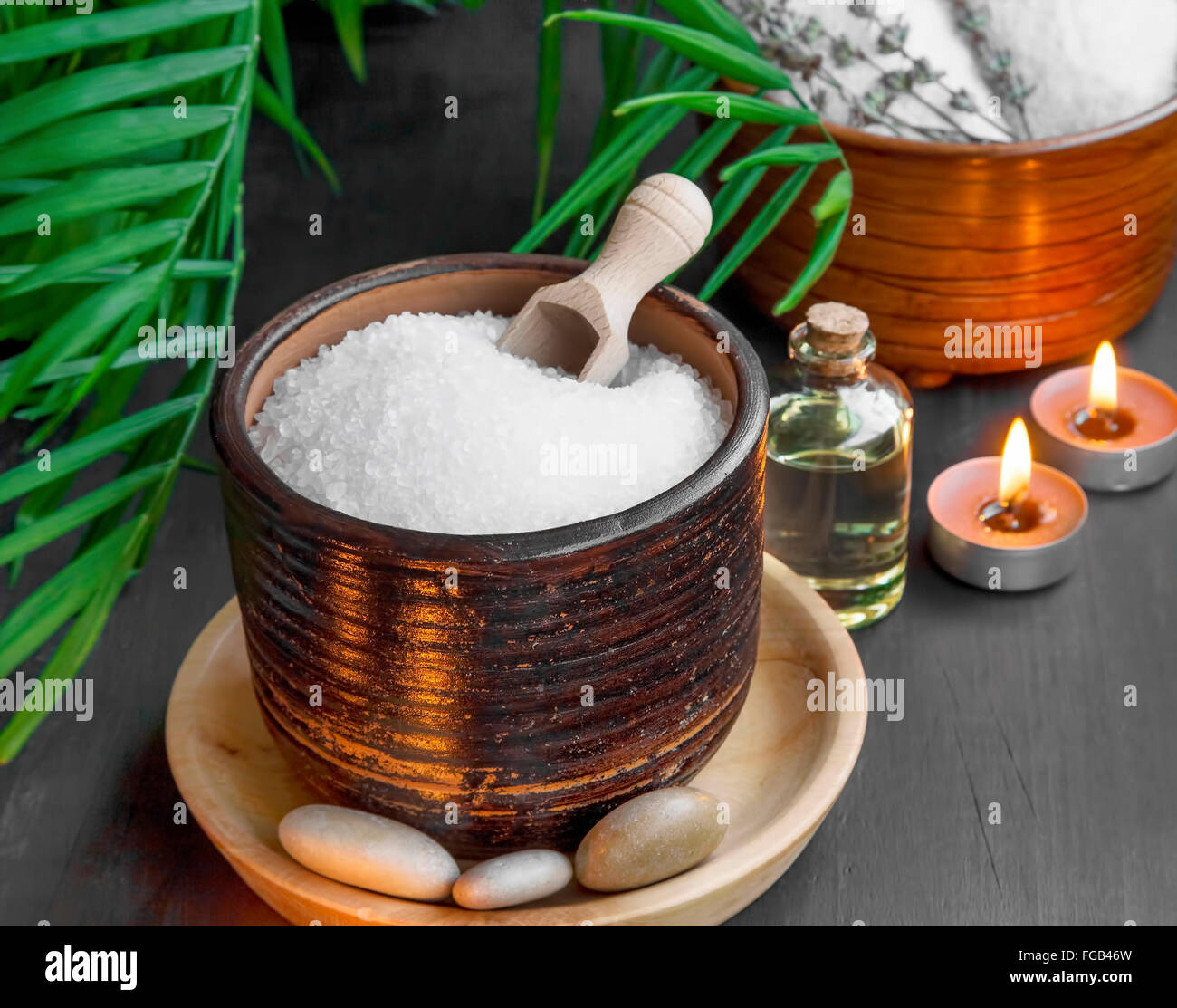 Spa-Einstellung mit Badesalz und Öl, massage, Steinen und brennenden Kerzen Stockfoto