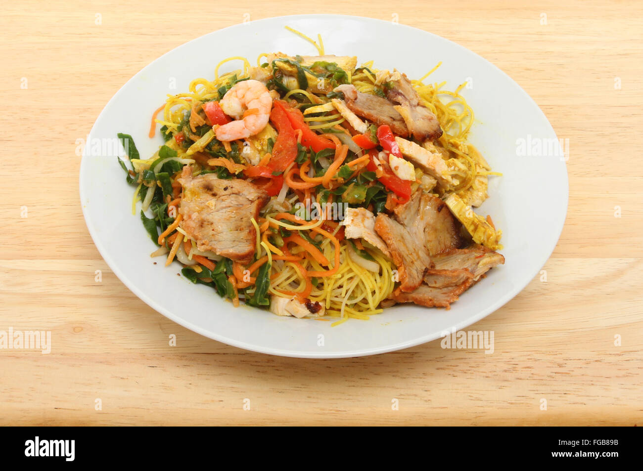 Chinesisches Essen, Singapur Nudeln in einer Schüssel auf einer hölzernen Tischplatte Stockfoto