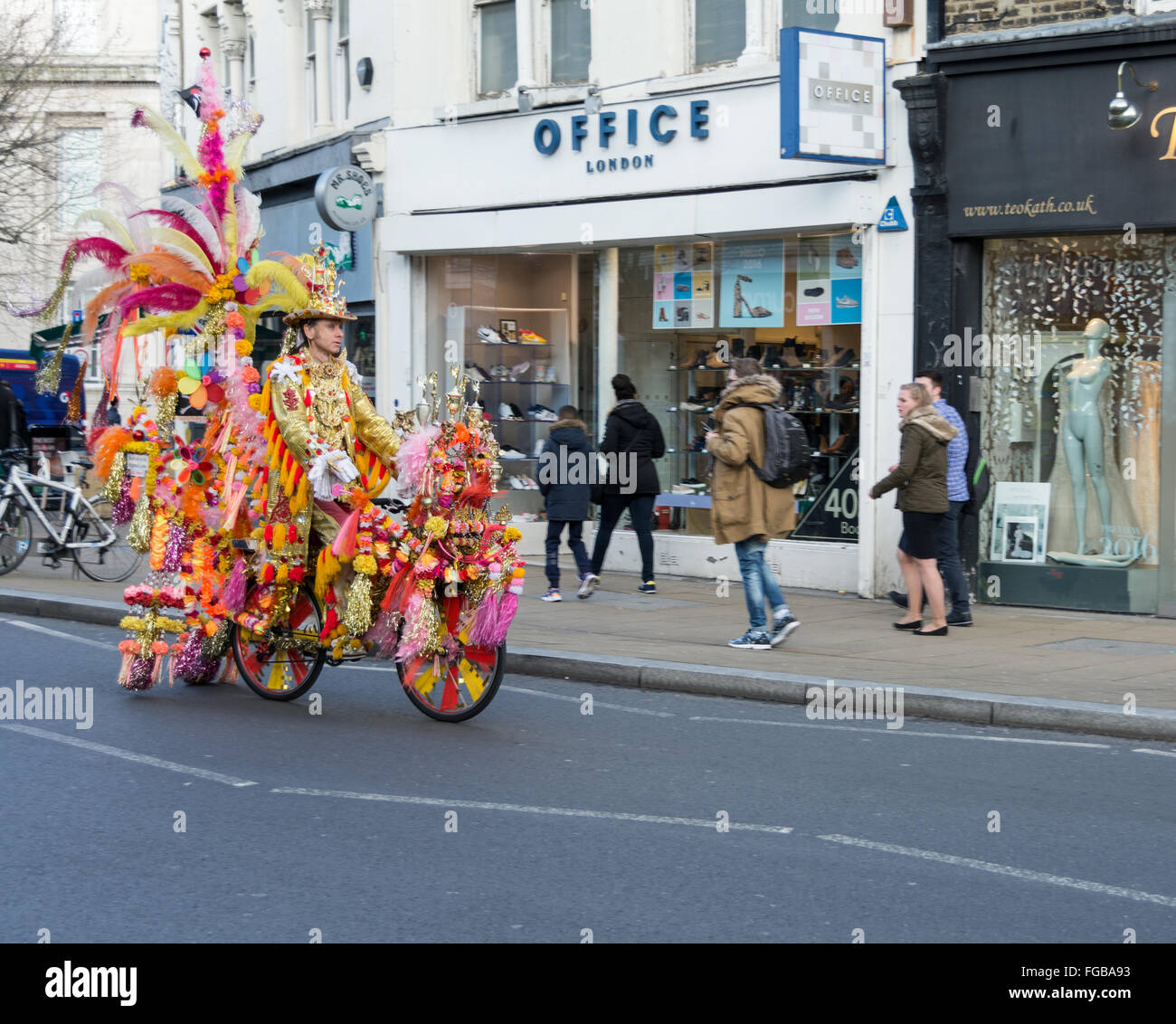 Der goldene Mann und seine herrliche Fahrrad in Wimbledon, SW, London, UK Stockfoto