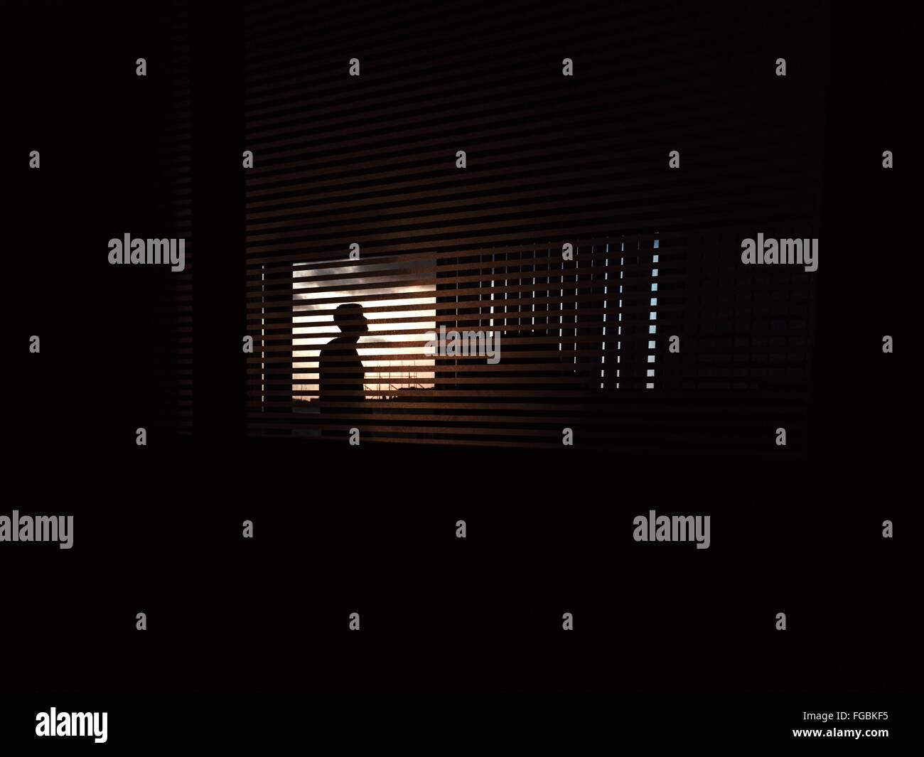 Silhouette Mann gesehen durch Jalousien Fenster Stockfoto