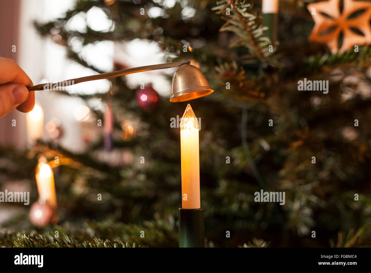 Candlesnuffer und elektrische Kerze am Weihnachtsbaum Stockfoto