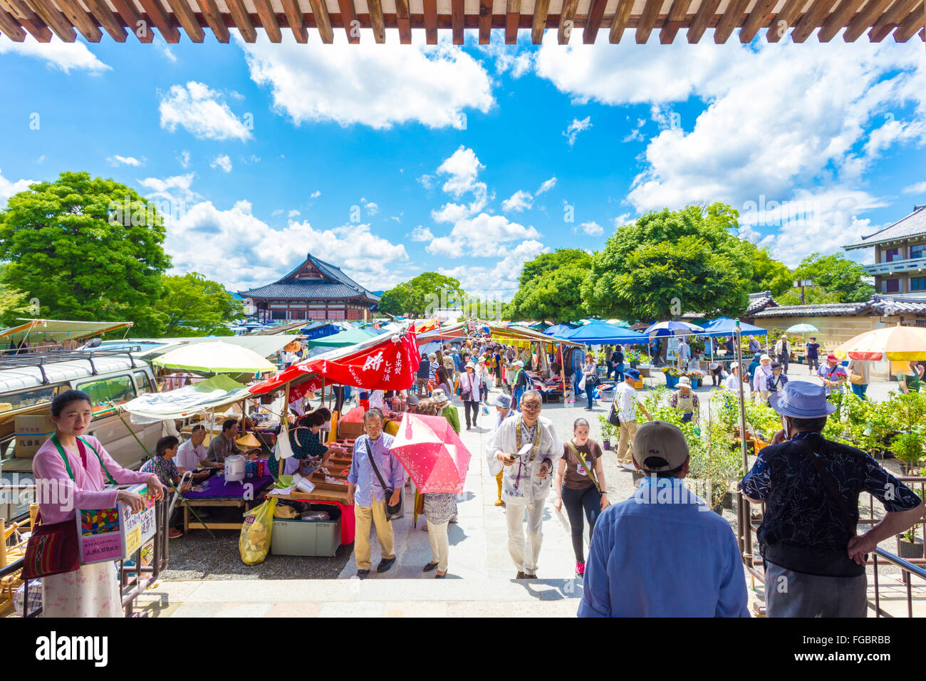 Menschen beim Einkaufen an Outdoor-Ständen von der einmal im Monat Toji-Markt auf dem Gelände des Tempels. Horizontale Stockfoto