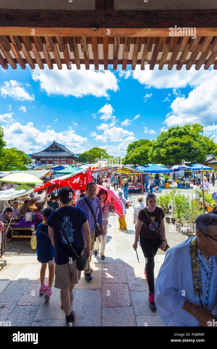Menschen beim Einkaufen an Outdoor-Ständen von der einmal im Monat Toji-Markt auf dem Gelände des Tempels. Vertikal Stockfoto