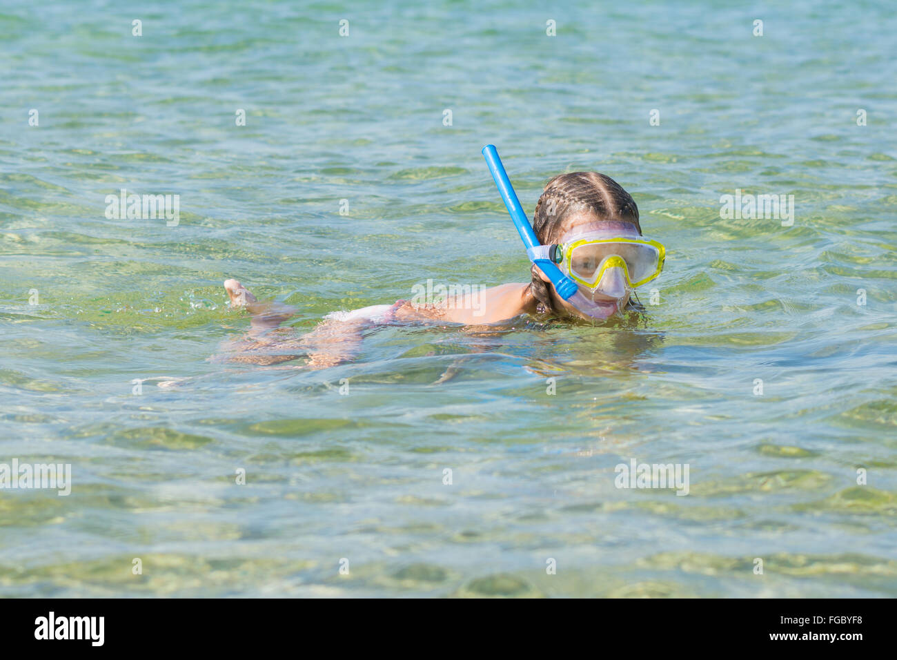 Sechsjährigen Mädchen schwimmt mit einer Maske und Schnorchel unter Wasser am Meer Stockfoto