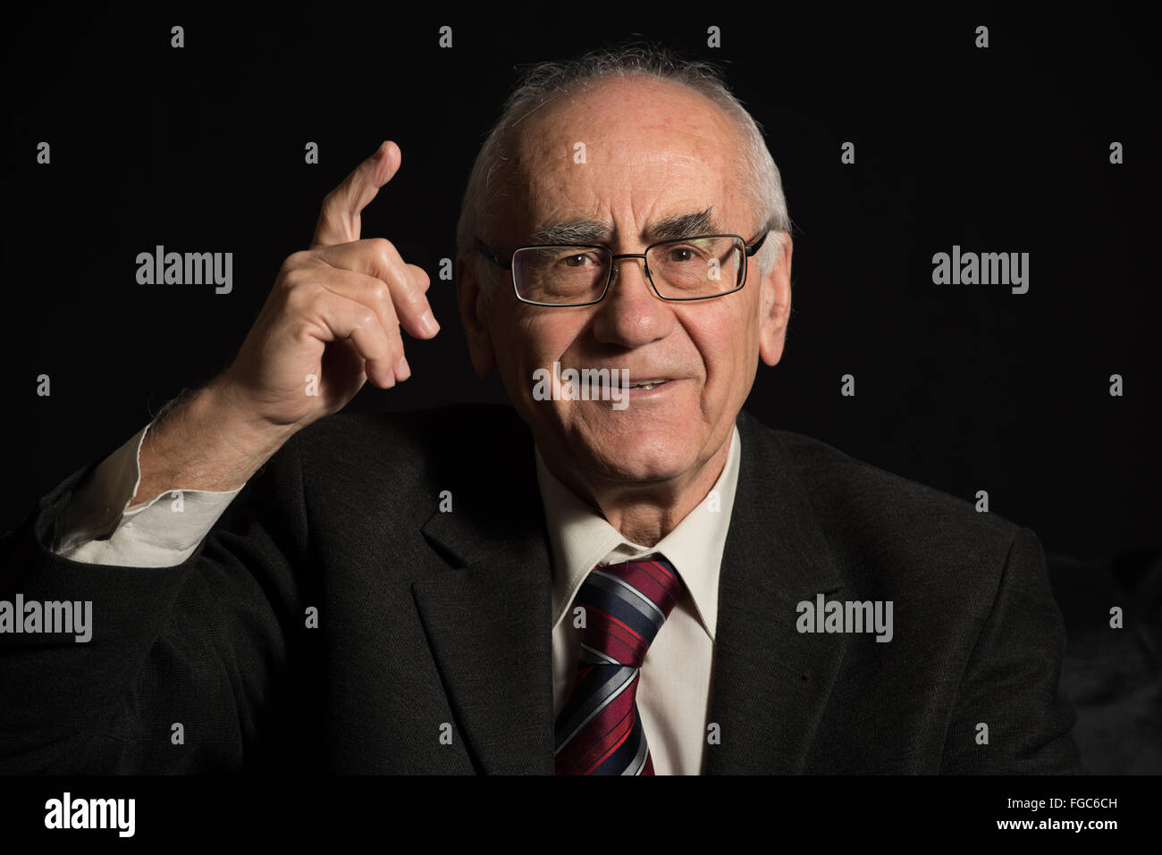 älteren Geschäftsmann, tragen Brillen auf schwarzem Hintergrund zeigt mit dem finger Stockfoto