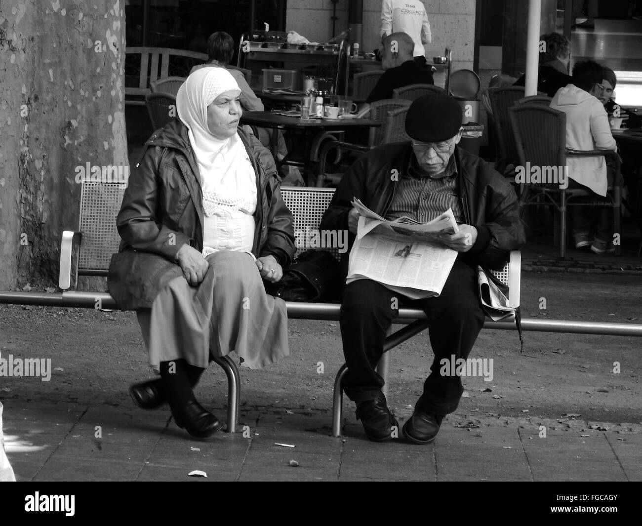 Leute sitzen auf einer Bank, Mann liest Zeitung, Bonn, Bottlerplatz, Deutschland Stockfoto