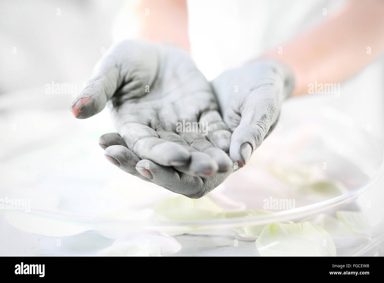 Die Hände von Frauen während der Chirurgie kosmetische Hände mit der angewandten Maske mit grüner Tonerde. Behandlung für die Hände. Stockfoto