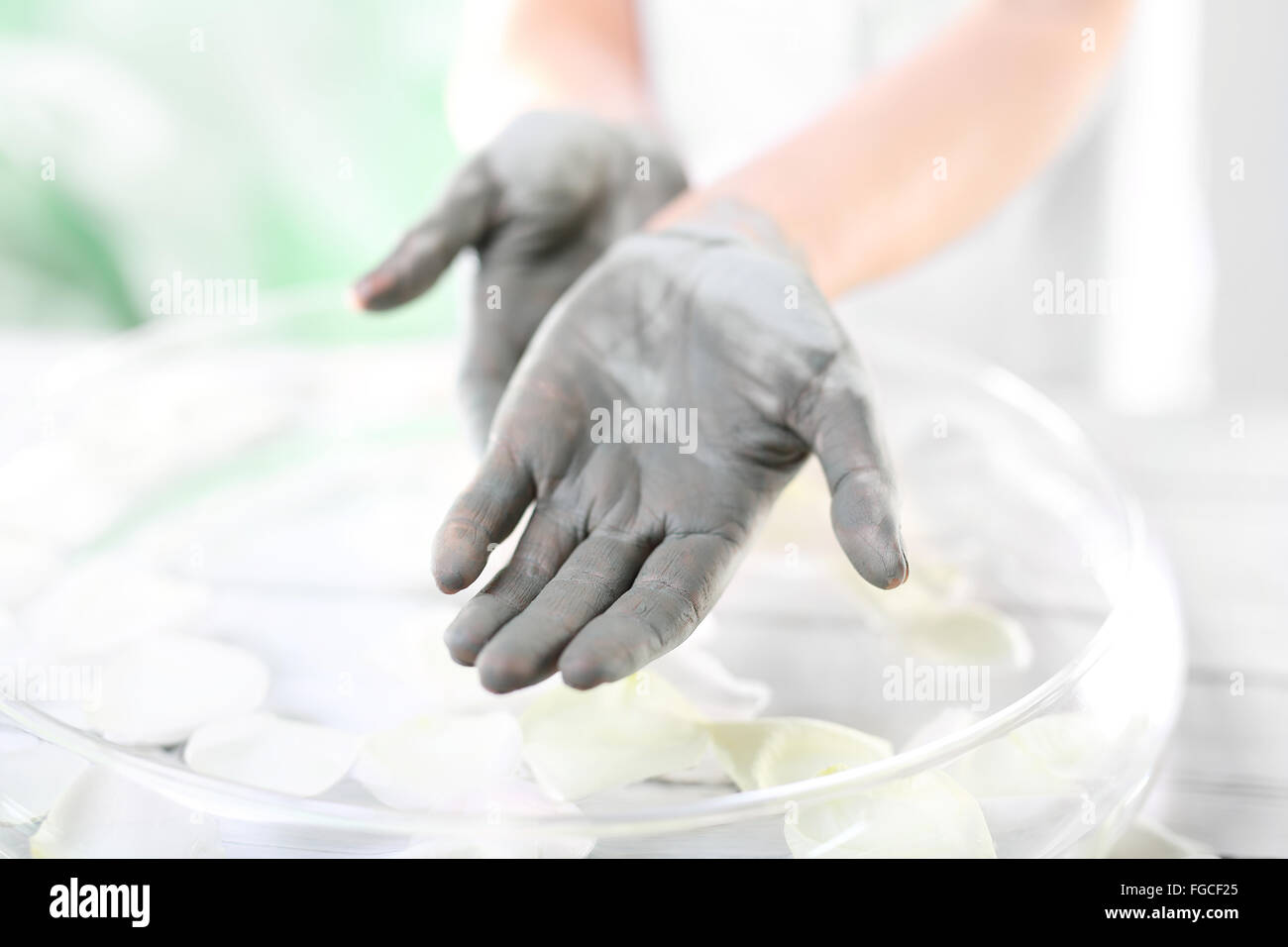 Die Hände von Frauen während der Chirurgie kosmetische Hände mit der angewandten Maske mit grüner Tonerde. Behandlung für die Hände. Stockfoto