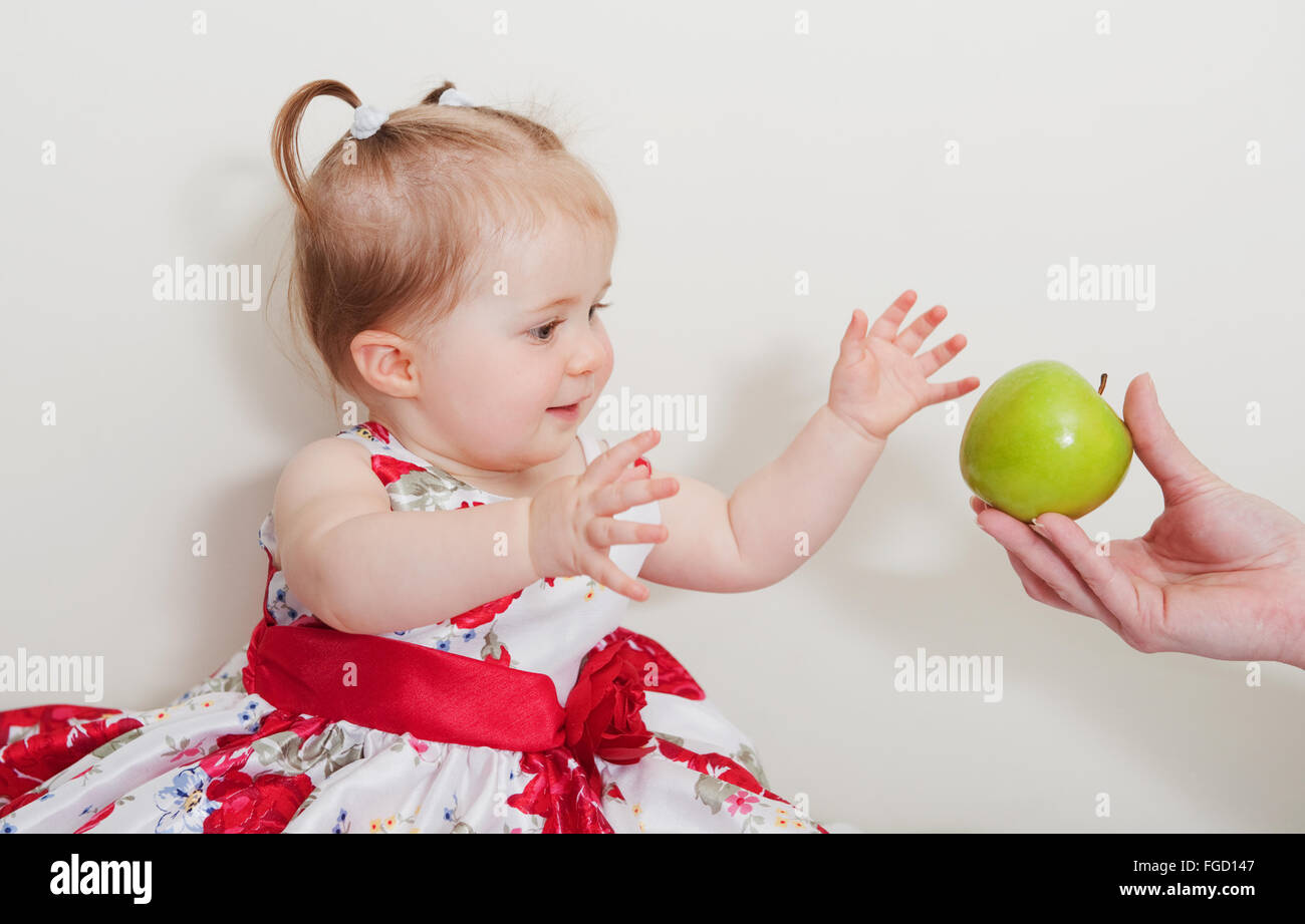 schöne Mädchen mit grünem Apfel auf einem hellen Hintergrund Stockfoto