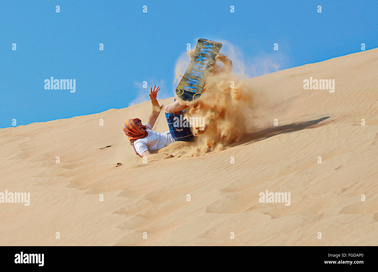 Sandboarding auf Sanddünen im Wahiba Sands, eines der beliebtesten Reiseziele der Tourisit im Oman. Stockfoto