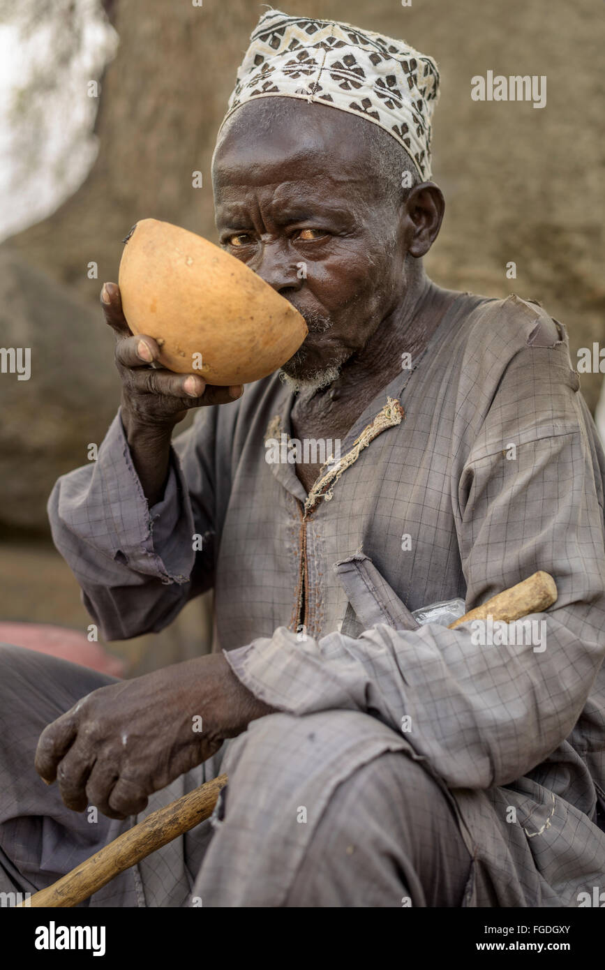 Menschen trinken Bier aus einer Clabash in einem Straßenmarkt. Stockfoto