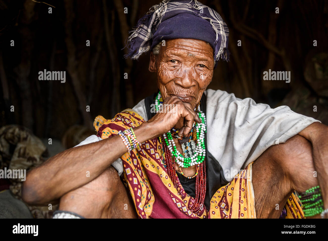 Porträt einer alten Frau aus dem Stamm der Buschmänner in ihrer Hütte in einem abgelegenen Teil der Kalahari-Wüste. Stockfoto