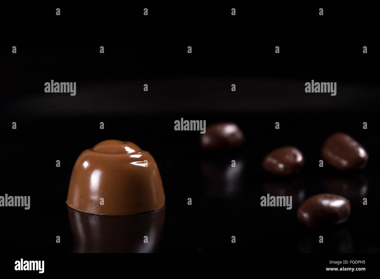 Schokolade Süßigkeiten auf einer reflektierenden Oberfläche schwarz Stockfoto