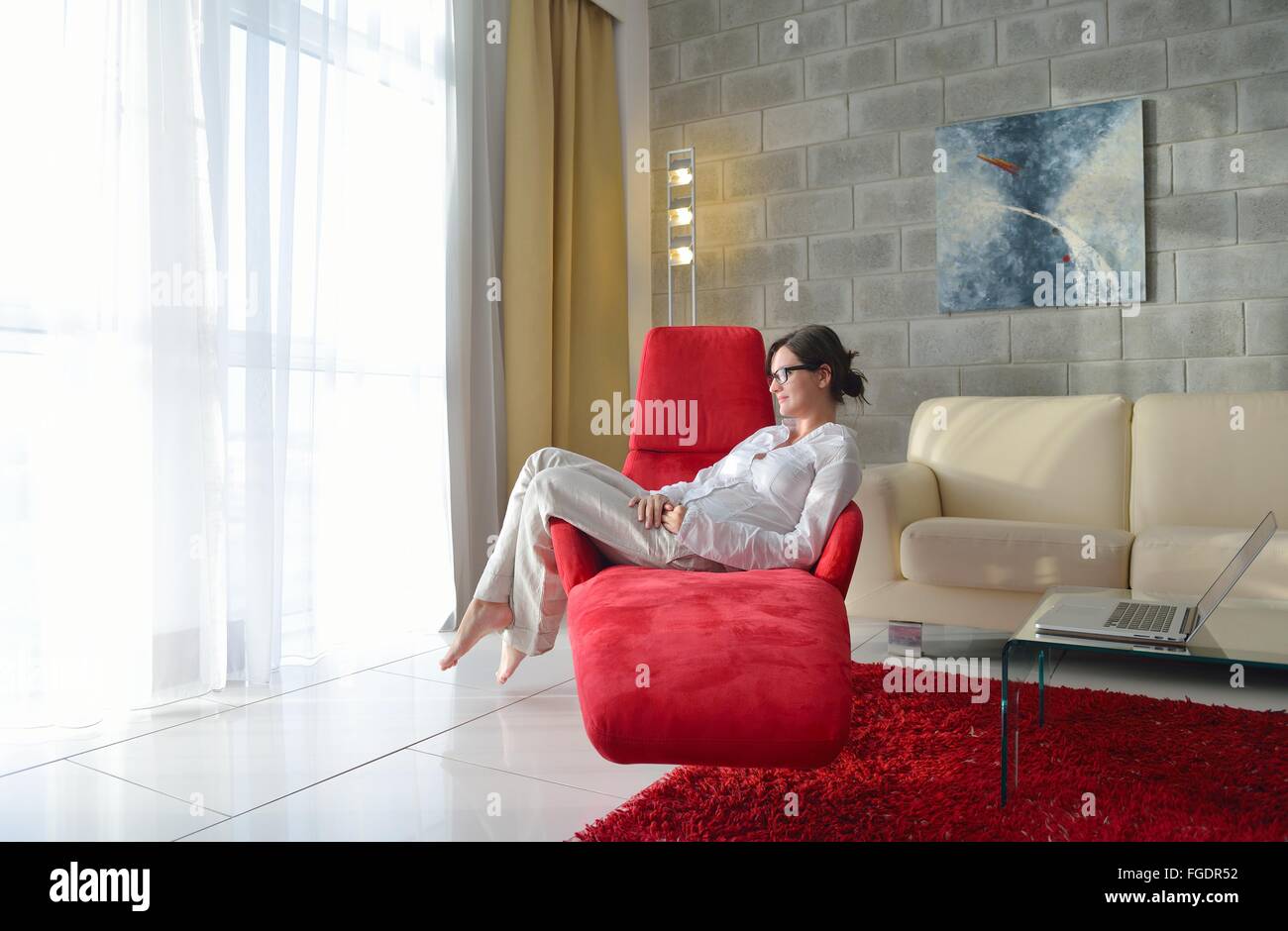 glückliche junge Frau entspannen Sie zu Hause auf sofa Stockfoto