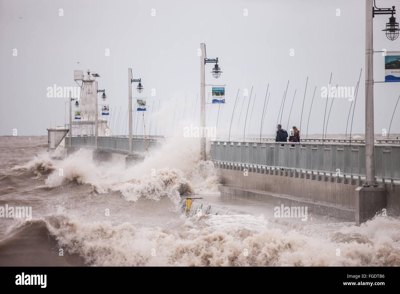 Port Stanley, Kanada - Oktober 3,2015. Wellen Absturz über die öffentlichen Pier in Port Stanley, wie ein paar versucht, bleiben trocken. Stockfoto