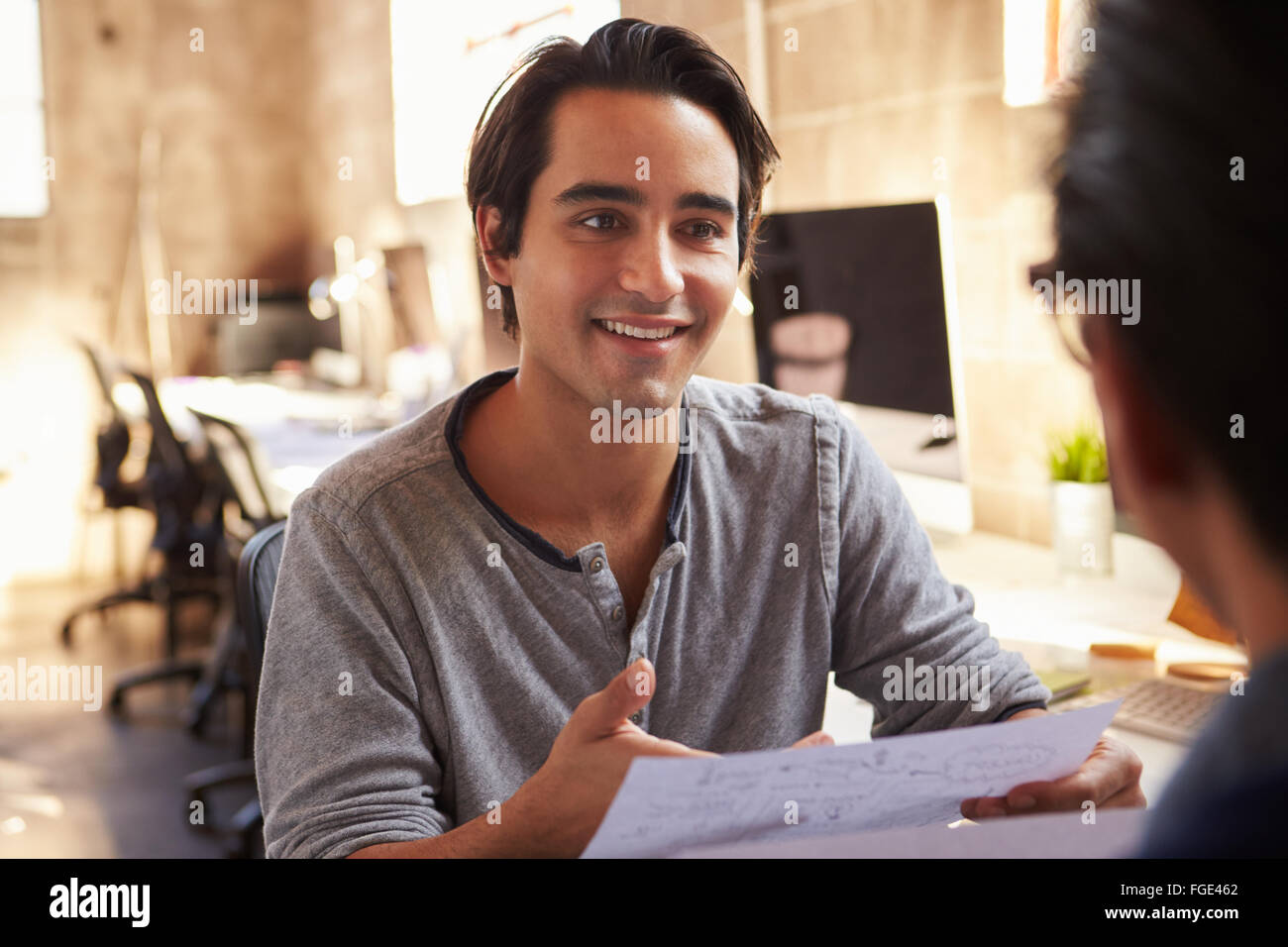 Zwei Designer besprechen Dokument während der Sitzung im Büro Stockfoto
