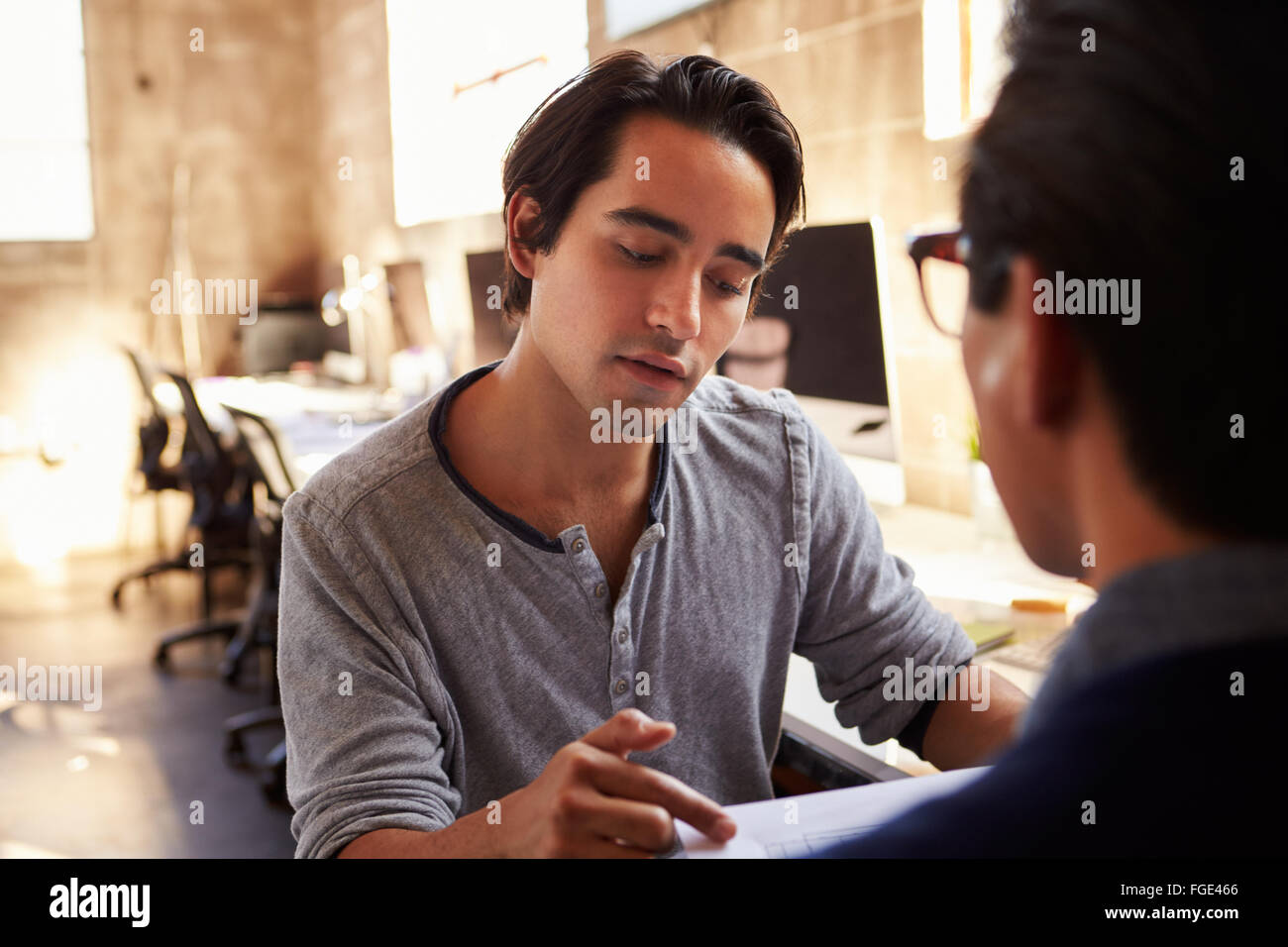 Zwei Designer besprechen Dokument während der Sitzung im Büro Stockfoto