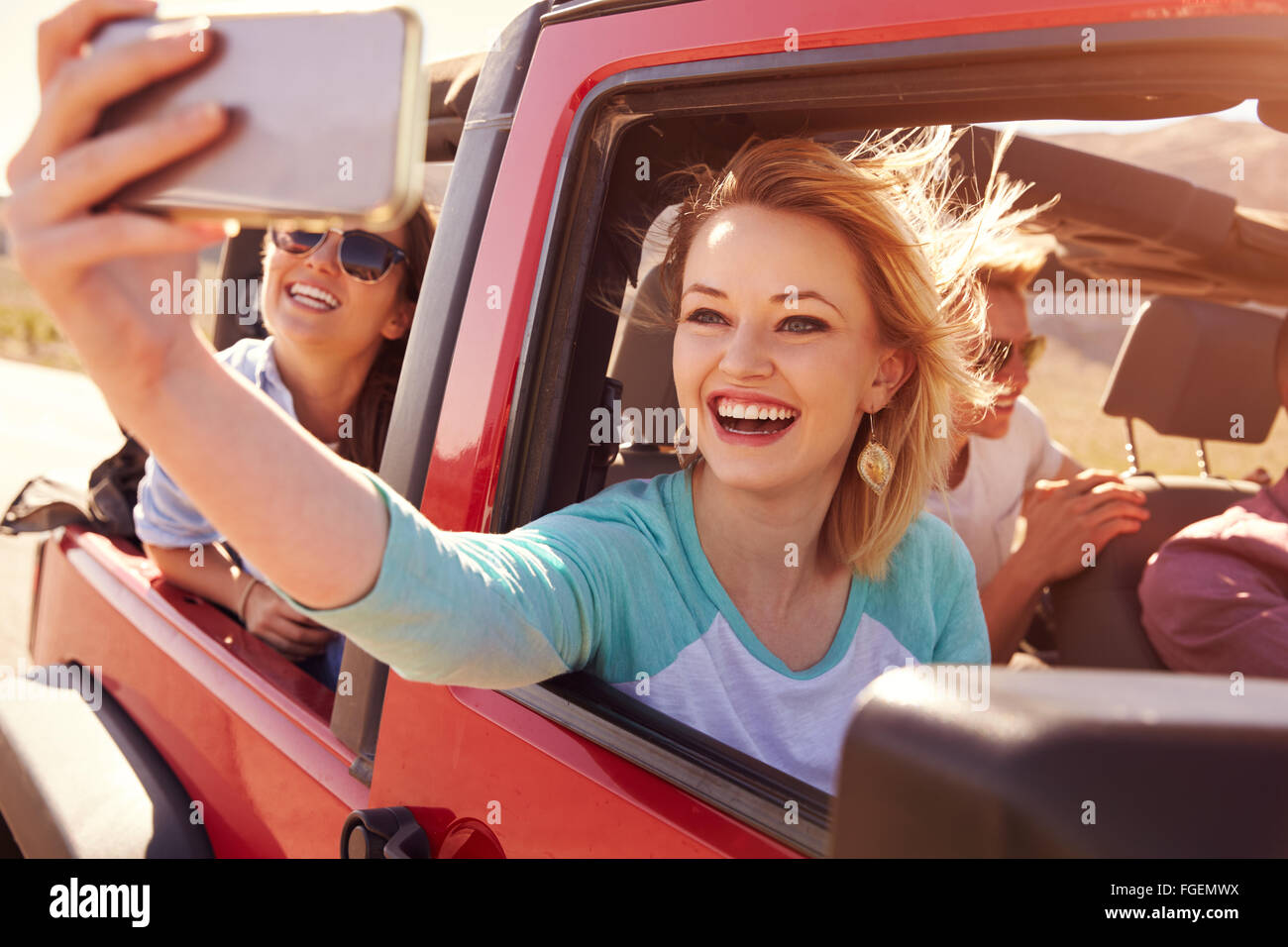 Freunde auf der Straße Reise im Cabrio nehmen Selfie Stockfoto