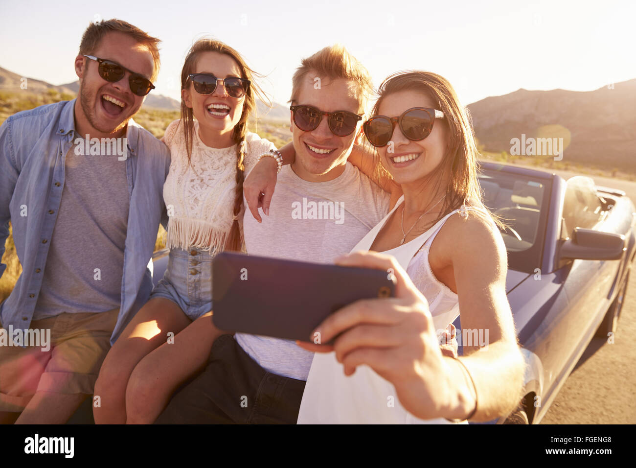 Freunde auf Roadtrip sitzen auf Cabrio nehmen Selfie Stockfoto