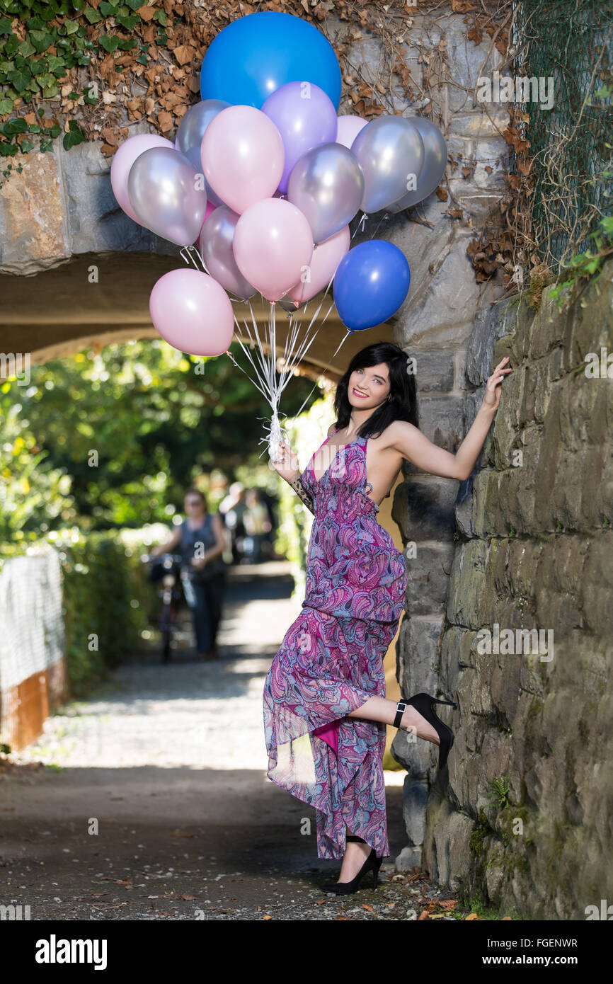 Junge Frau mit langen Kleid posiert mit bunten b Stockfoto