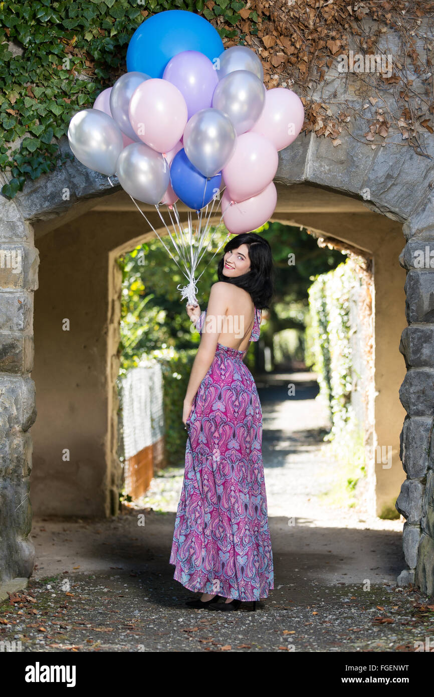 Junge Frau mit langen Kleid posiert mit bunten b Stockfoto